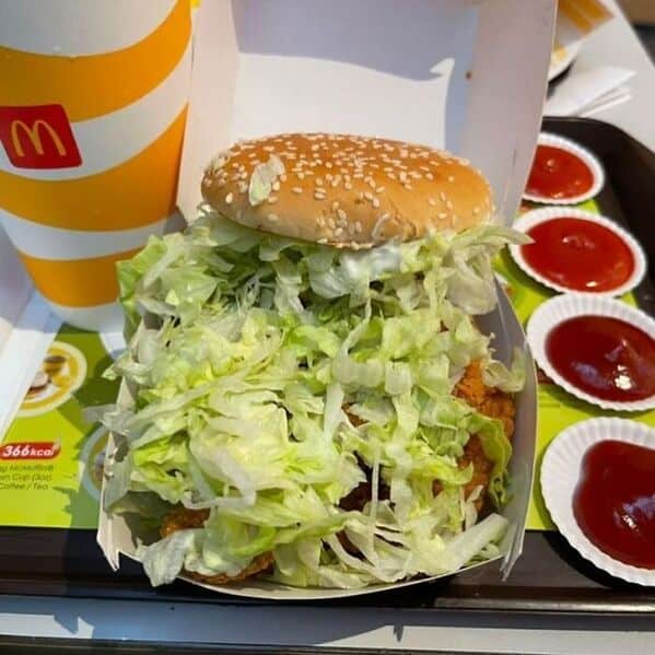 McDonald's burger overflowing with absurd mountain of shredded lettuce piled high above the bun