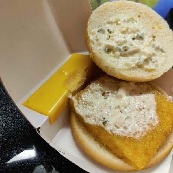McDonald's Filet-O-Fish opened showing tartar sauce smeared on bun with tiny corner of cheese