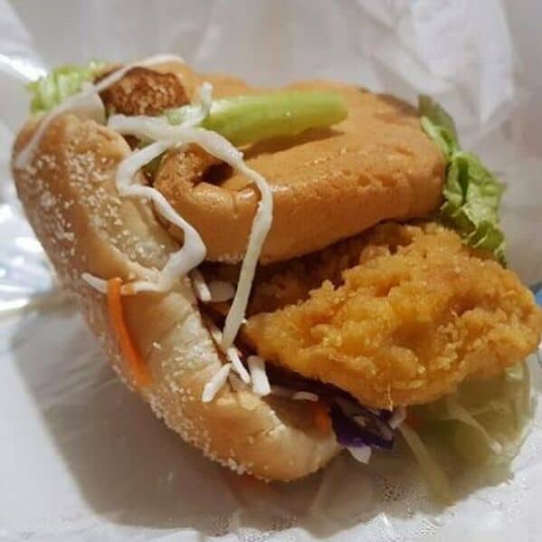 Sloppy McDonald's chicken sandwich fail with cabbage and lettuce spilling out of crooked bun