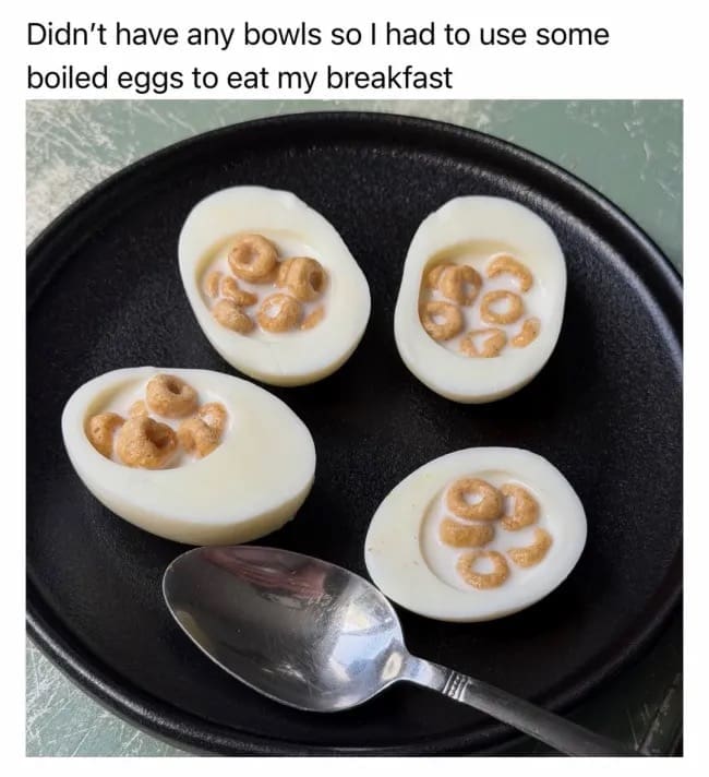 A "cursed food" meme dump entry showing a black plate with four hard-boiled egg whites. Instead of yolks, the eggs have been filled with milk and cereal loops, serving as a desperate, bowl-free breakfast solution.