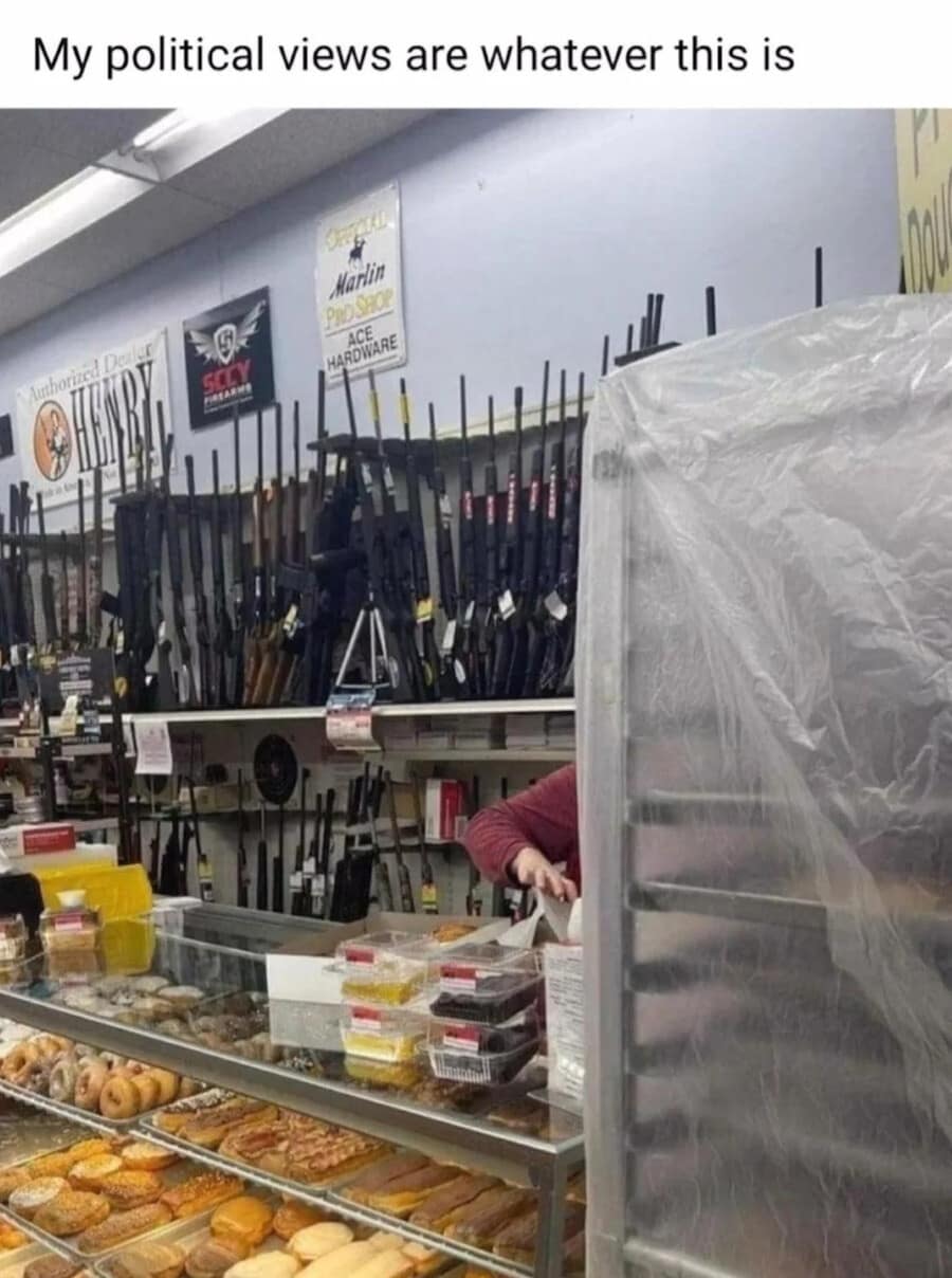 A meme dump entry capturing the ultimate "American Dream" store: a wide-angle shot of a counter where the bottom half is a display of fresh, glazed donuts and the top half is a wall-to-wall rack of rifles and shotguns, captioned: "My political views are whatever this is."