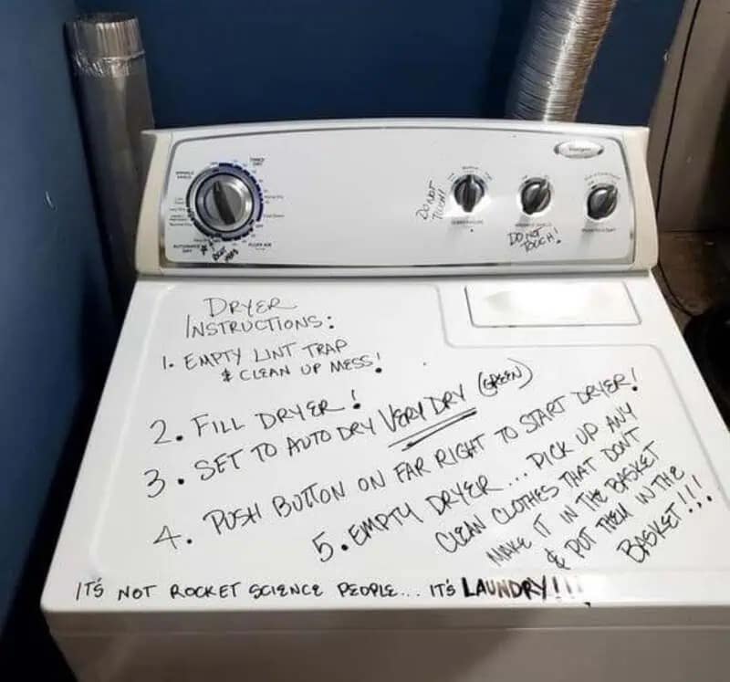 aggressive funny meme featuring a white laundry dryer. Someone has used a black marker to write a massive, numbered list of "DRYER INSTRUCTIONS" directly onto the top of the machine, ending with the frustrated bottom line: "IT'S NOT ROCKET SCIENCE PEOPLE... IT'S LAUNDRY!!!"