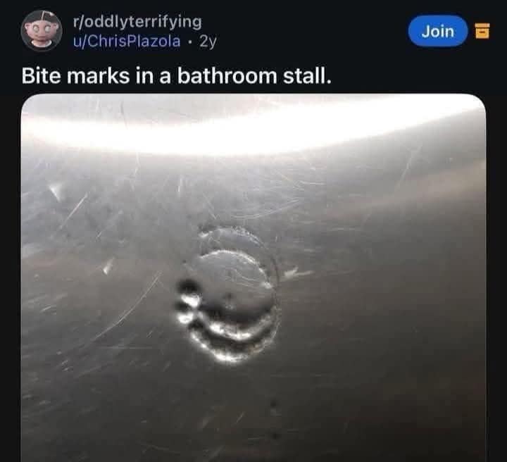 A weirdly hilarious meme originally from the "oddly terrifying" subreddit, showing a close-up of a metallic bathroom stall door with a deep indentation that looks remarkably like human bite marks.