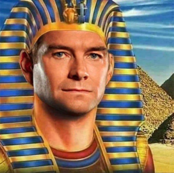cursed funny meme featuring a high-quality edit of actor Antony Starr (Homelander from The Boys) as an ancient Egyptian Pharaoh. He wears the Nemes headdress while a pyramid stands in the background, staring with an unnervingly smug expression.