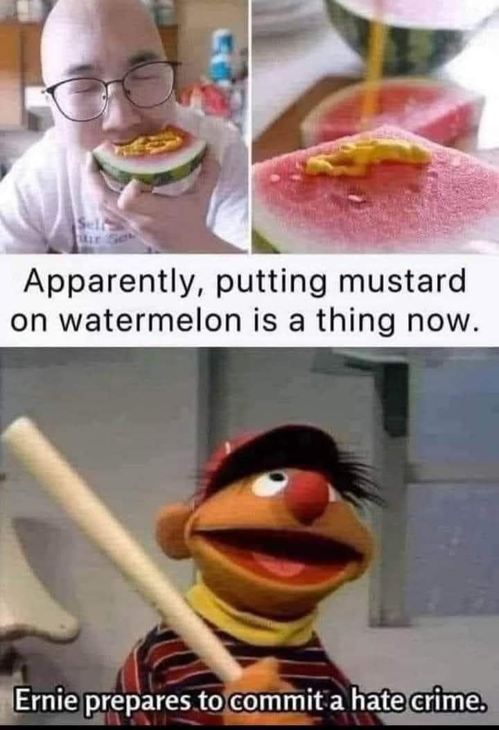 A funny meme calling out bizarre food trends. The top panels show a man eating a slice of watermelon topped with yellow mustard. The bottom panel features Ernie from Sesame Street holding a baseball bat with the caption: "Ernie prepares to commit a hate crime."