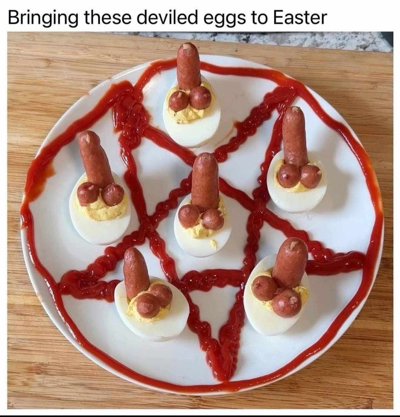 A chaotic culinary funny meme showing a plate of "deviled eggs" arranged in a pentagram made of ketchup. Each egg is topped with a cocktail sausage standing upright, looking like a suggestive and vaguely occult appetizer.