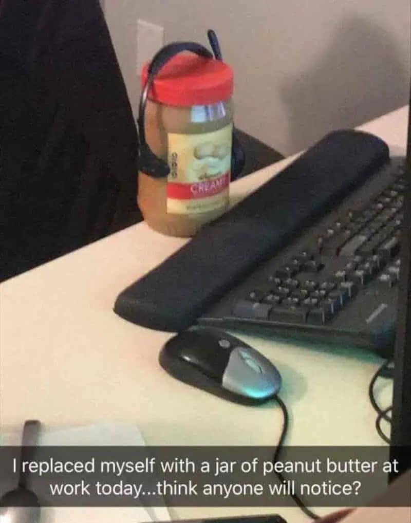 A "quiet quitting" masterpiece: a workstation featuring a keyboard, mouse, and a jar of creamy peanut butter wearing a professional headset. The Snapchat caption asks, "I replaced myself with a jar of peanut butter at work today...think anyone will notice?"