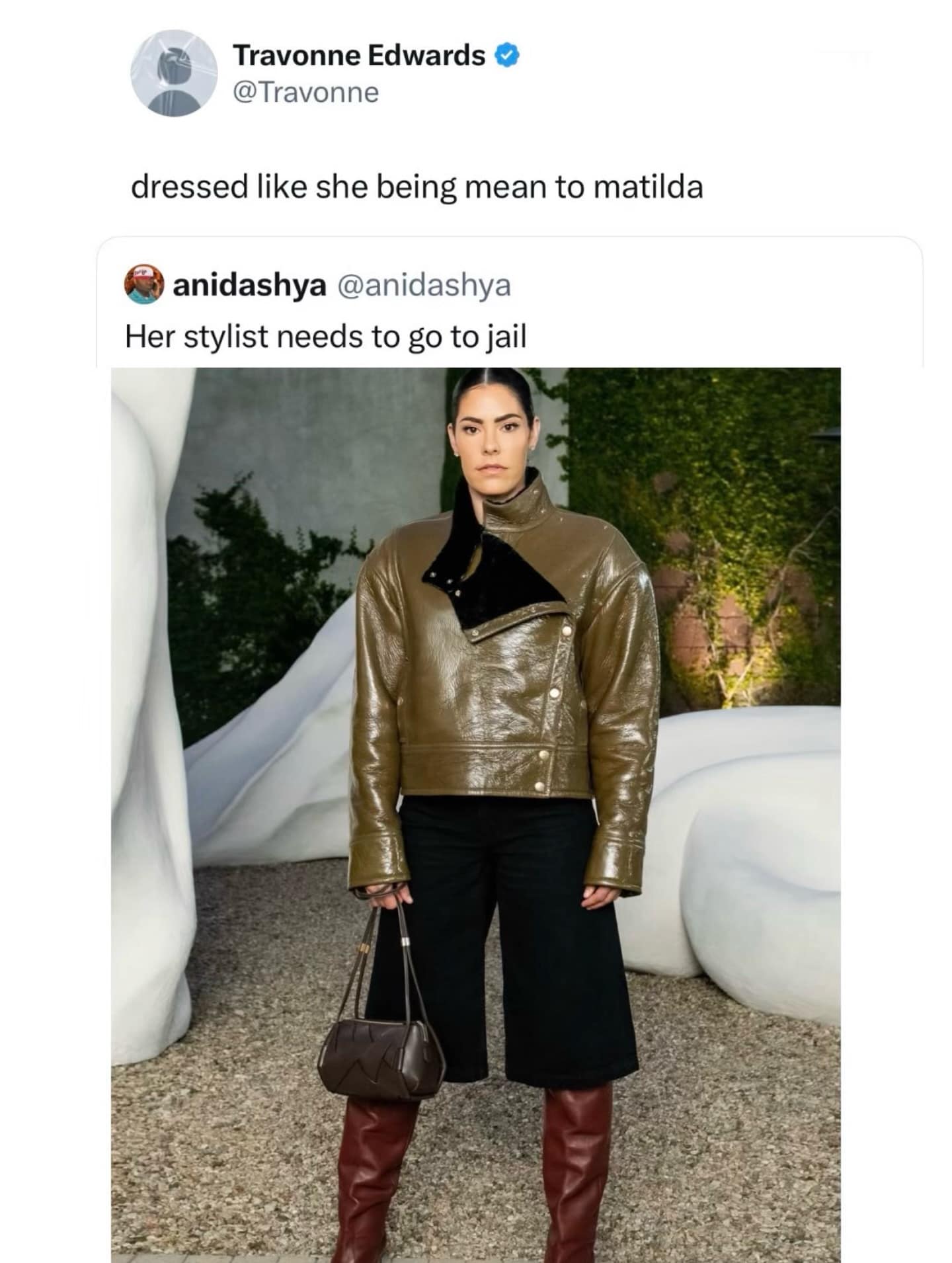 A fashion-critique funny meme featuring a woman in an avant-garde olive-green vinyl coat and culottes. A quote tweet from Travonne Edwards hilariously observes that she is "dressed like she being mean to matilda," a clear reference to the villainous Miss Trunchbull.