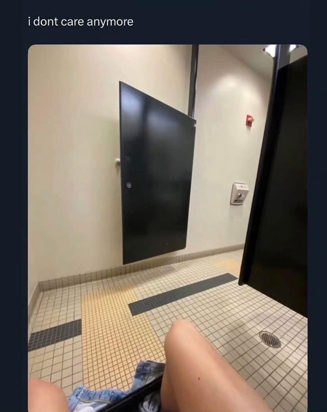 A POV shot from inside a public restroom stall where the door has been completely removed or shifted to the side, leaving the user totally exposed. This image from a recent meme dump perfectly captures a state of total nihilistic exhaustion with the top text i dont care anymore.