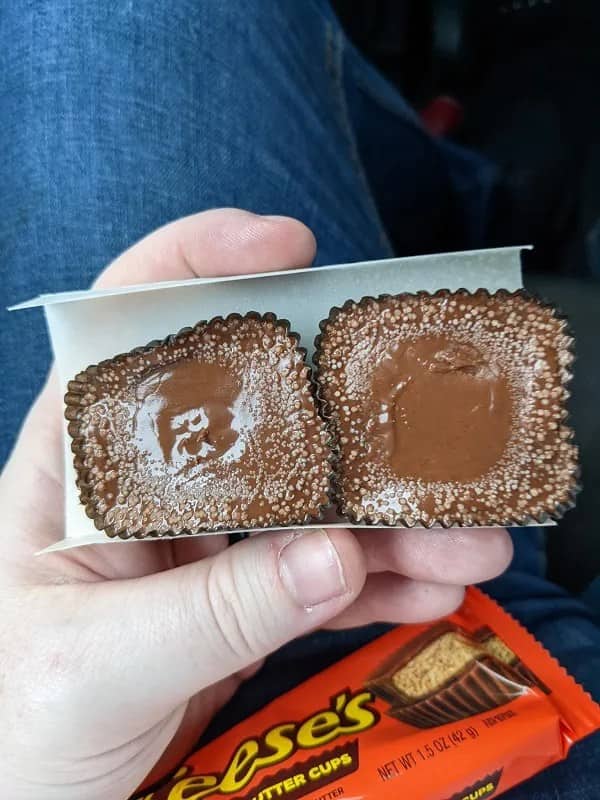 Melted hollow Reese's peanut butter cups with no filling visible inside wrappers