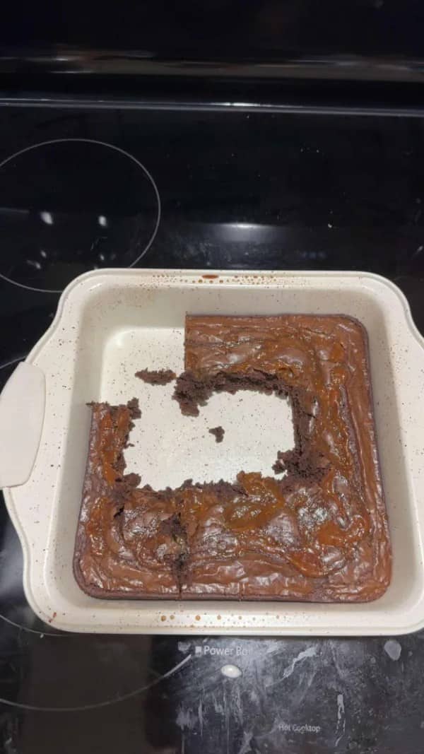 Brownie pan with entire center scooped out leaving only crumbled edges behind