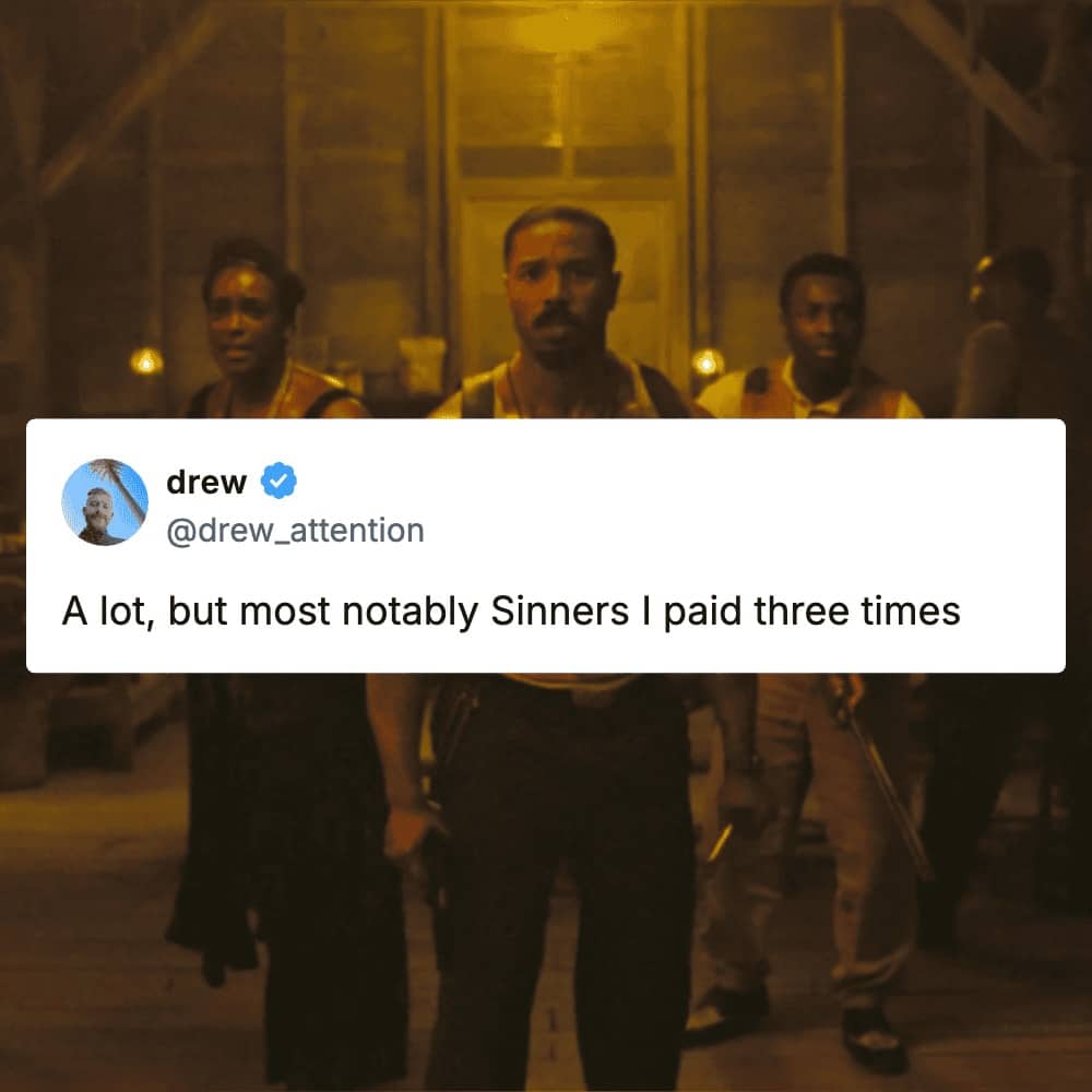 Michael B. Jordan in the film Sinners standing with a group in a dark room.