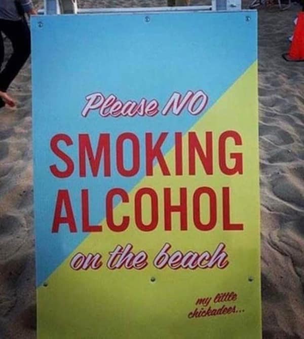 A confusingly phrased beach safety sign in this no context image that reads "Please NO SMOKING ALCOHOL on the beach," followed by an unsettling and strangely affectionate sign-off: "my little chickadees...".