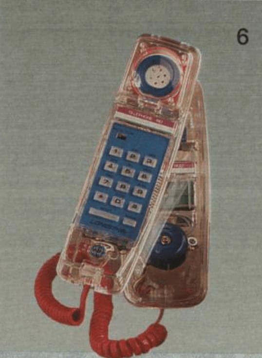 A vintage landline phone featuring a clear, see-through plastic body. The internal blue ringer bell and wiring are visible, and it is paired with a striking red coiled cord.