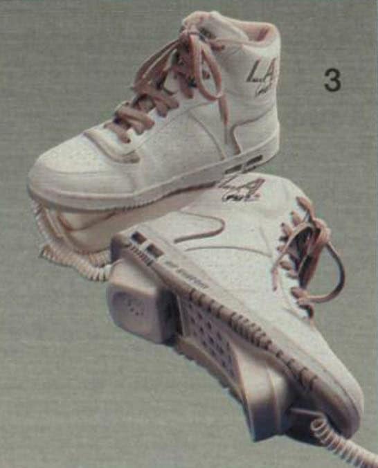 An iconic novelty landline phone shaped like Garfield the cat. The lazy orange tabby's eyes open and close depending on whether the receiver is docked. The matching orange handset features a standard black push-button keypad