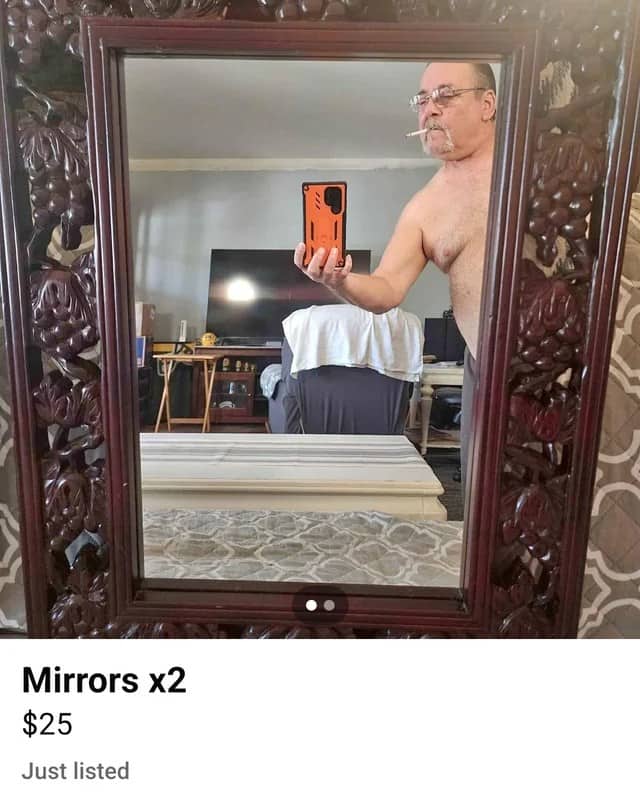 Carved wooden framed mirror for sale reflecting shirtless man with cigarette in mouth