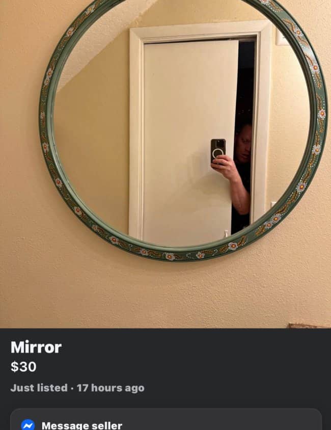 Round decorative mirror for sale with seller peeking out from behind doorway