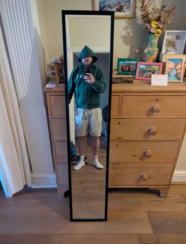 Long narrow full length mirror for sale reflecting man in hoodie taking selfie