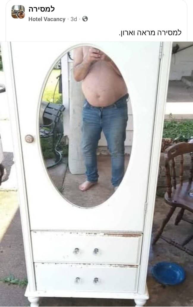 Oval mirror wardrobe for sale reflecting shirtless man in jeans holding phone outdoors