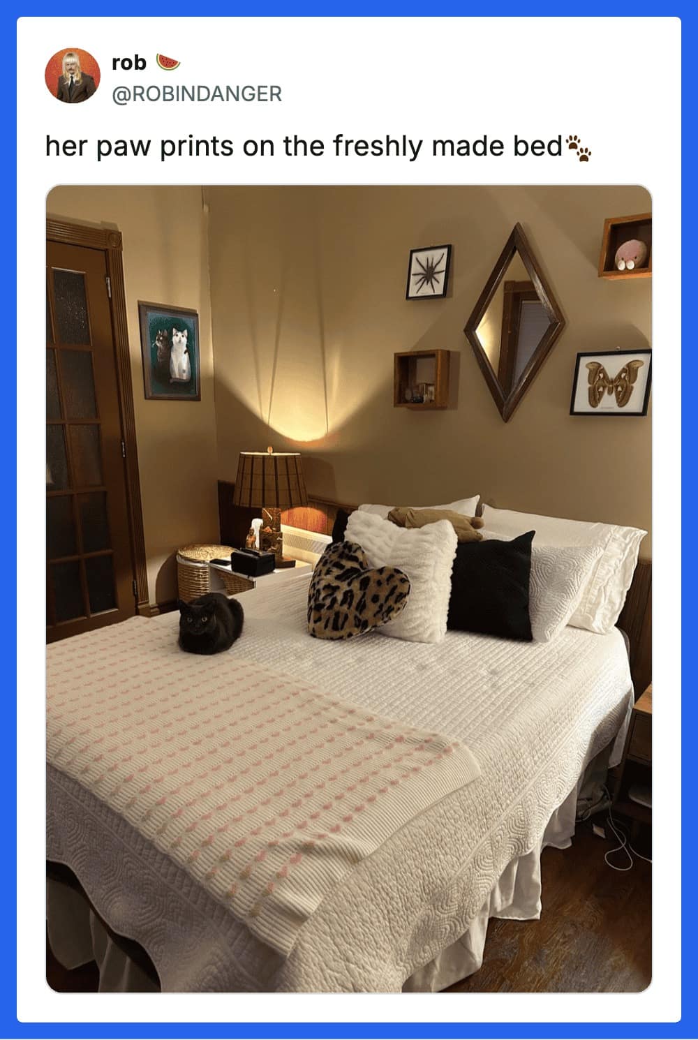 A visually satisfying cat meme showing a pristine, white, freshly made bed in a warm-toned room. A small black cat sits regally on the duvet, which is dotted with a trail of tiny, dark paw prints leading to her spot.