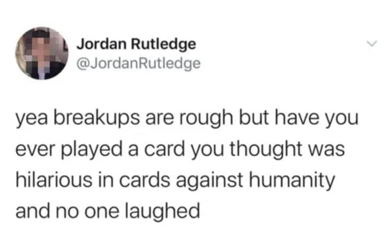 Tweet comparing post-breakup pain to playing a Cards Against Humanity card that gets zero laughs.