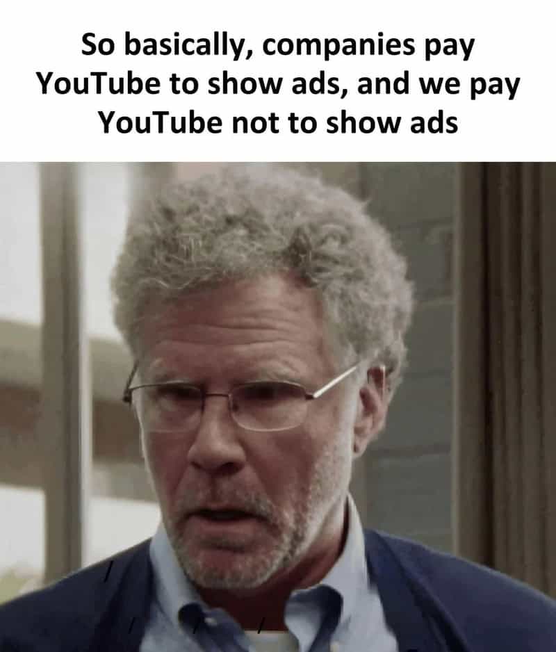 Will Ferrell looks suspicious and baffled in a relatable meme about modern subscription models. The text points out the circular irony where companies pay YouTube to show ads, while users pay YouTube specifically to hide those same ads.