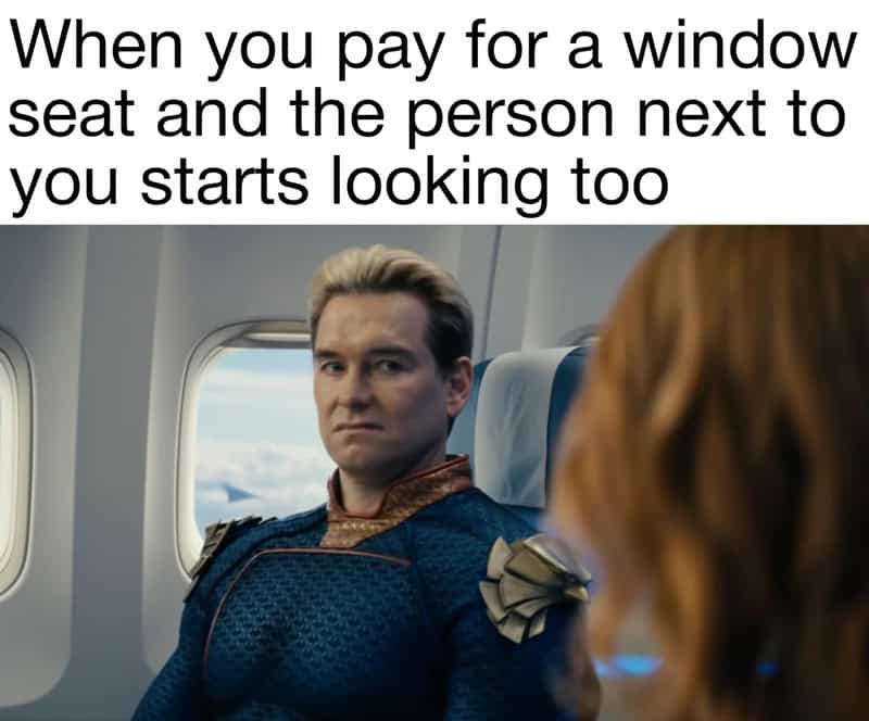 Homelander sits on an airplane in this relatable meme about personal space and paid extras. He stares daggers at the passenger next to him who is trying to peek through the window seat he specifically paid for.