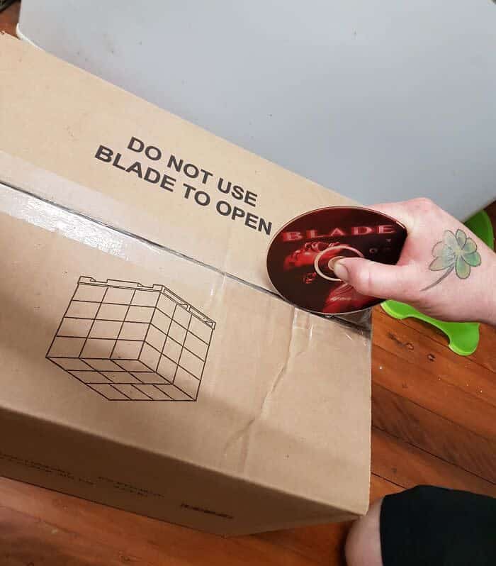 Person using Blade DVD to open box labeled do not use blade to open funny irony