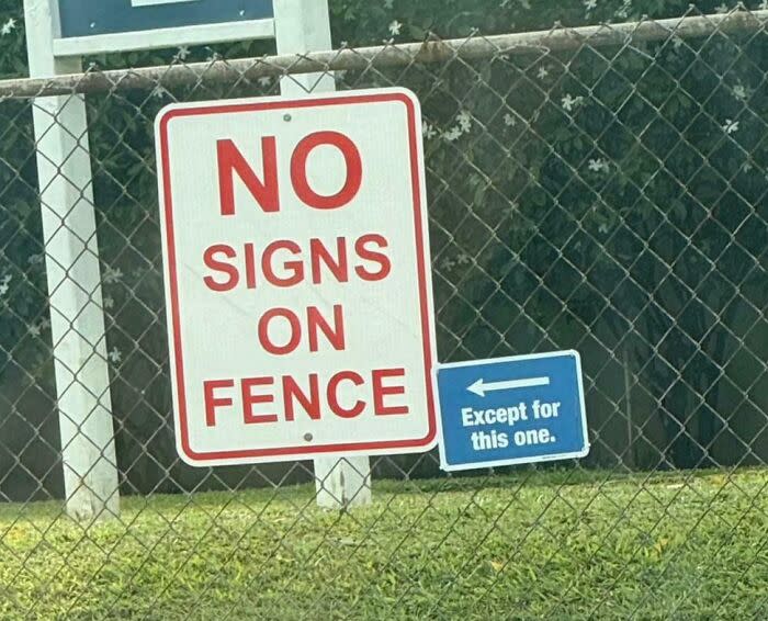 No signs on fence sign next to smaller blue sign reading except for this one