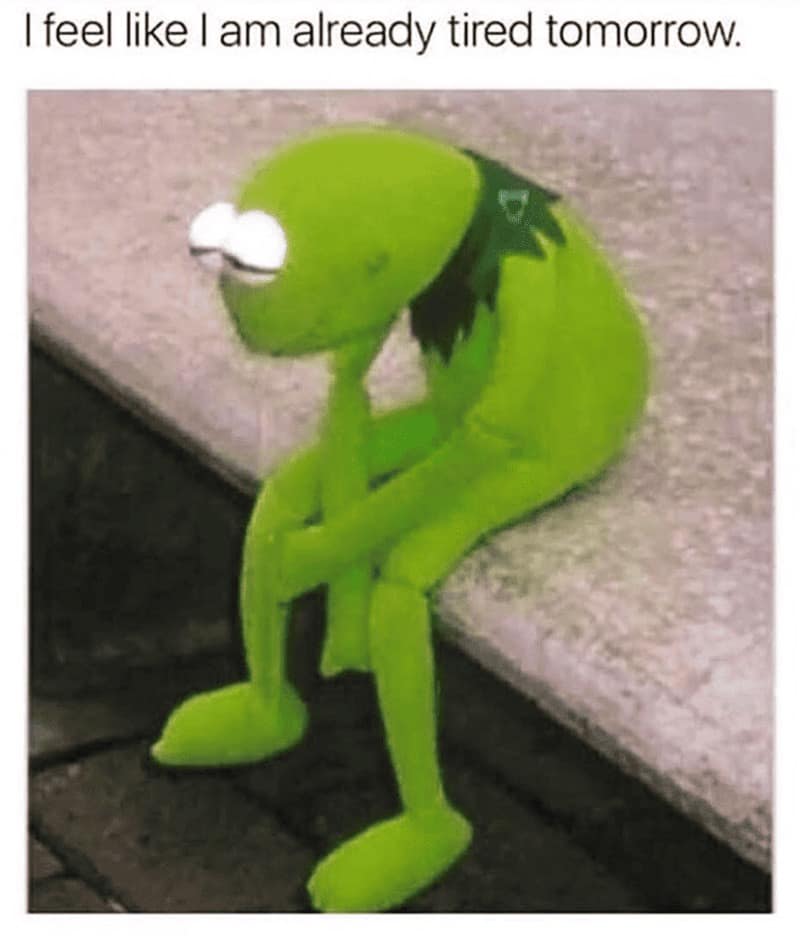 A relatable sleep meme featuring Kermit the Frog sitting slumped and dejected on a concrete curb. The text defines a specific brand of modern burnout: "I feel like I am already tired tomorrow."