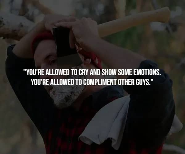 Bearded lumberjack in red plaid swings axe overhead in snowy woods, illustrating emotions as a legitimate masculine skill.