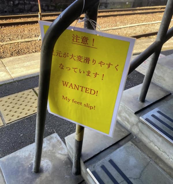 translation fail posted on a train station staircase. Instead of a standard caution about slippery steps, the yellow sign dramatically screams "WANTED!" in red letters, followed by the personal confession: "My feet slip!"