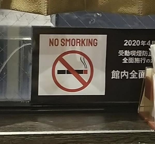 translation fail on a "No Smoking" sticker. Below the international symbol of a crossed-out cigarette, the text has a typo that turns a health warning into a funny command: "NO SMORKING."