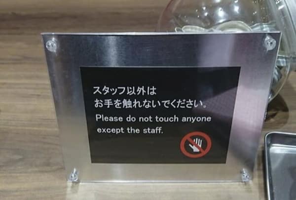 flirtatious translation fail on a museum or shop display sign. Meant to stop people from touching delicate items, the English text instead instructs: "Please do not touch anyone except the staff."