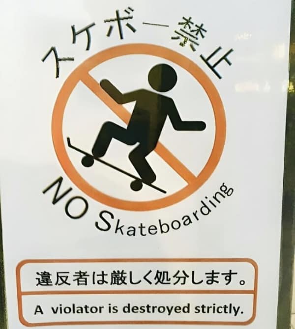 An intense translation fail on a "No Skateboarding" sign. The Japanese warning about strict punishment for violators is translated into a hardcore threat: "A violator is destroyed strictly."