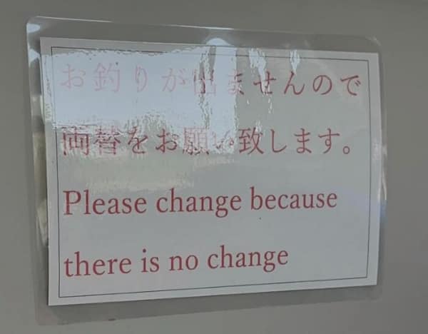 An existentially heavy translation fail on a simple request for exact change. The sign's intended message is likely "Please use correct change," but the English translation provides a deep philosophical demand: "Please change because there is no change."