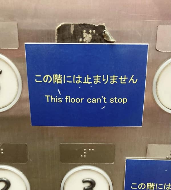 A high-energy translation fail on an elevator button panel. A blue sticker intended to inform passengers that the elevator does not stop on a specific floor instead gives the building a life of its own with the text: "This floor can't stop."