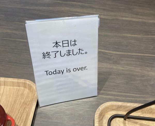 translation fail on a cafe counter sign. The Japanese text likely indicates that service is finished for the day, but the English translation takes it to a much more dramatic, end-of-the-world level: "Today is over."