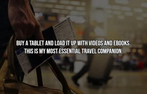 A travel hack highlighting a tablet as the most essential companion when loaded with ebooks and videos. The image shows a traveler's hand holding a boarding pass and a leather bag in a blurred airport terminal.