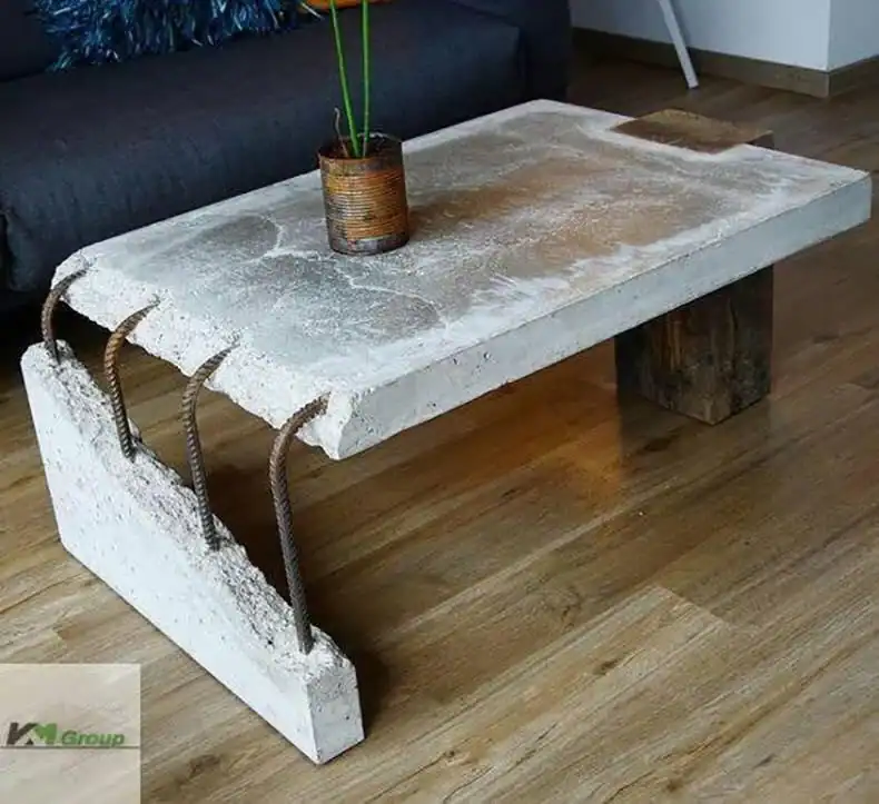 Rough concrete slab coffee table with exposed rebar legs sitting on hardwood living room floor