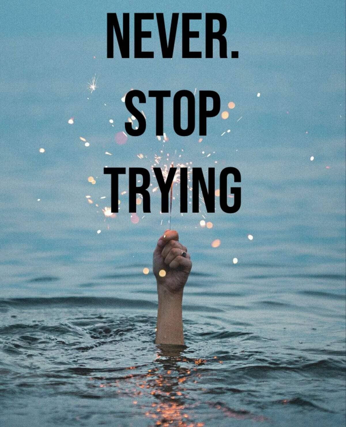 Hand rising from ocean holding sparkler with deadpan caption telling reader to never stop trying.