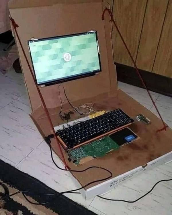 DIY cardboard laptop build with exposed circuit board keyboard and screen held by string