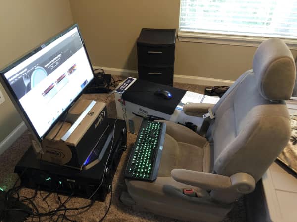 Gaming PC setup using a minivan bucket seat as an office chair in bedroom