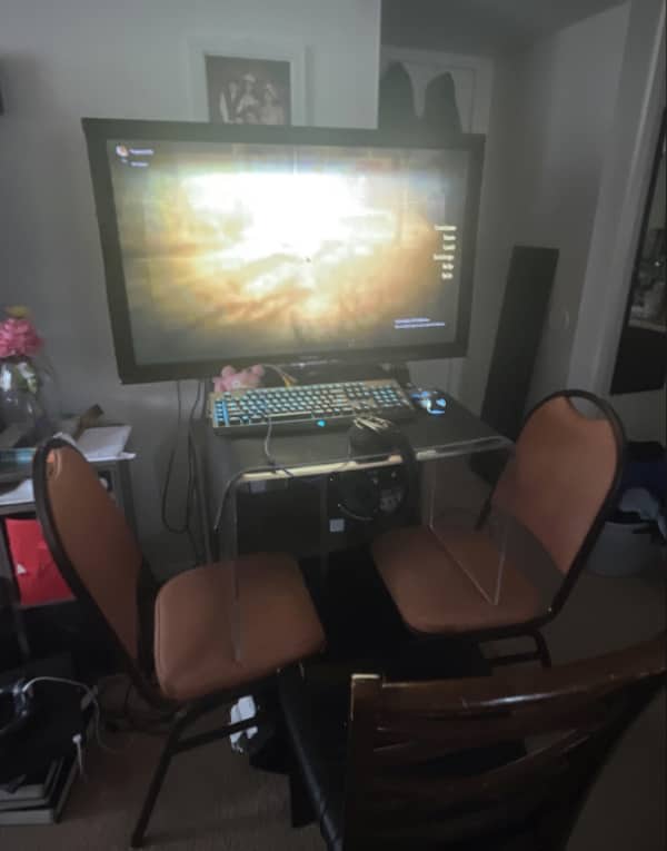 Gaming PC desktop squeezed between two folding banquet chairs with no actual desk chair