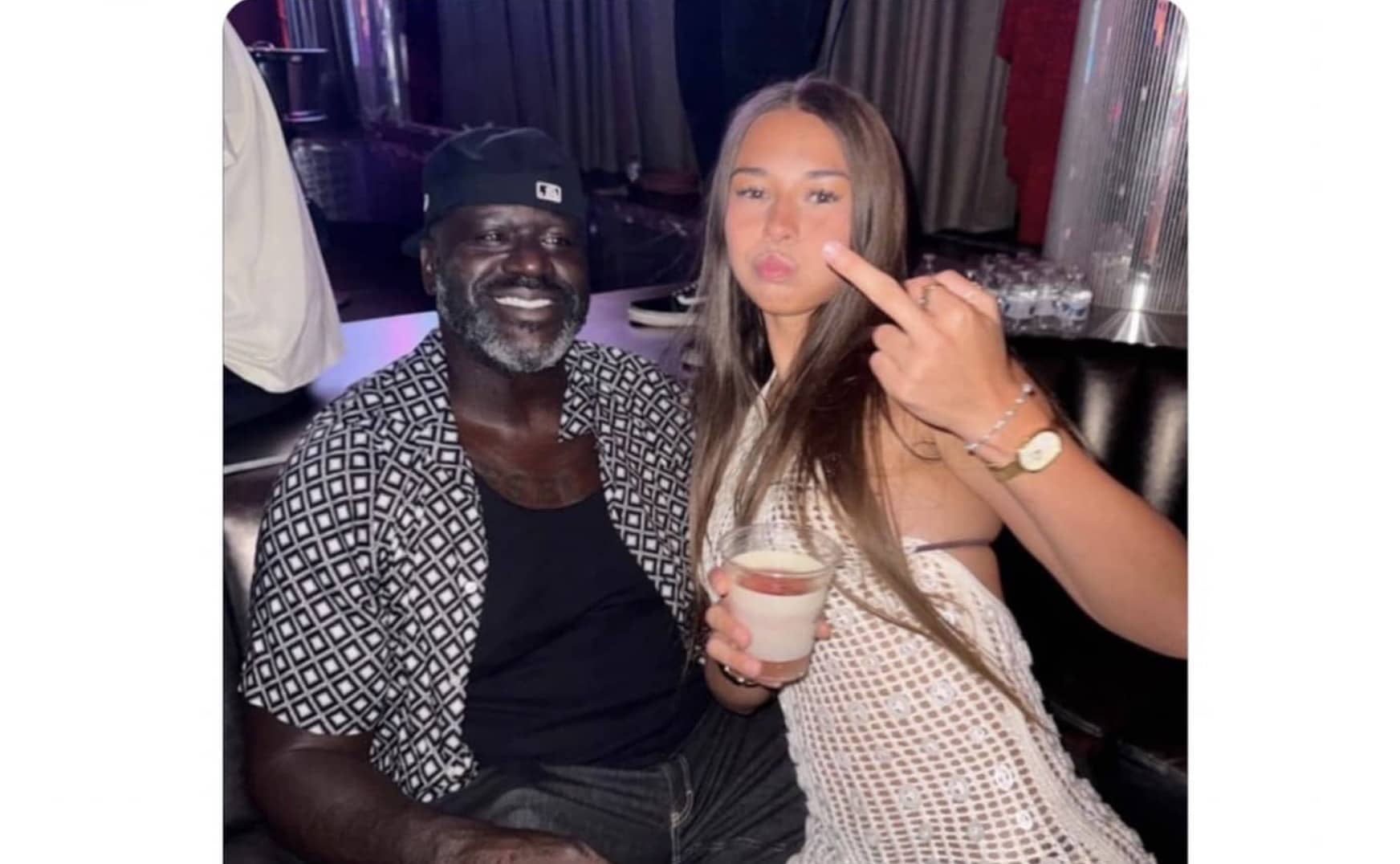 Shaquille O'Neal smiling next to a woman holding a drink and making a playful face.