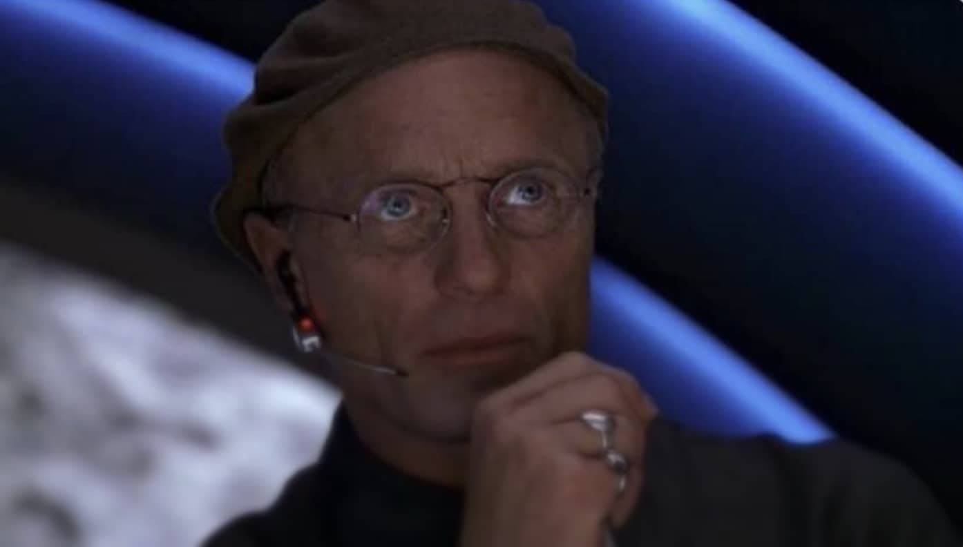 Close up of Ed Harris as Christof from The Truman Show wearing a beret and headset.