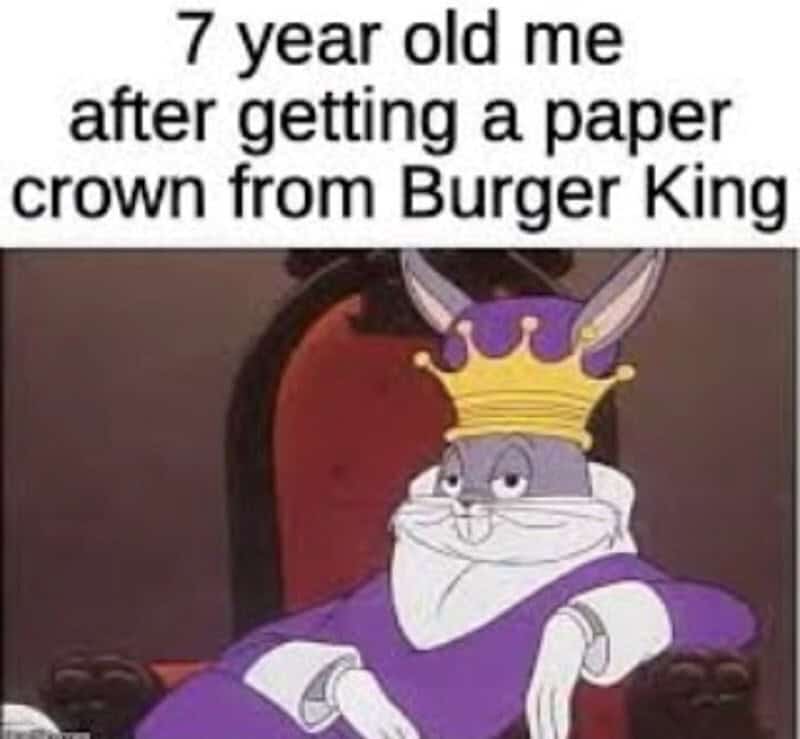 A regal Gen X meme featuring a smug Bugs Bunny wearing a purple cape and gold crown, representing the absolute peak of status: getting a paper crown from Burger King.