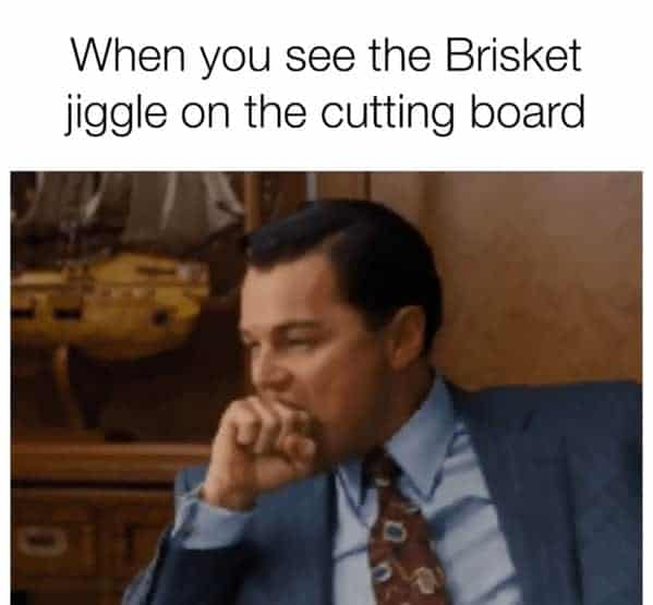 A cinematic bbq meme featuring Leonardo DiCaprio biting his fist in overwhelmed desire from The Wolf of Wall Street, paired with text capturing the intense moment a pitmaster watches a smoked brisket jiggle on the cutting board.