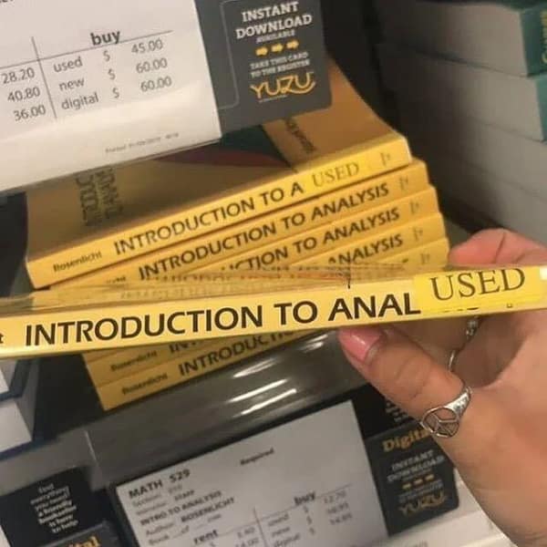 A hand holds a college textbook spine reading "INTRODUCTION TO ANALYSIS" where a library retail "USED" sticker accidentally patches over the ending letters to spell out a highly inappropriate alternative title in a classic blursed image.
