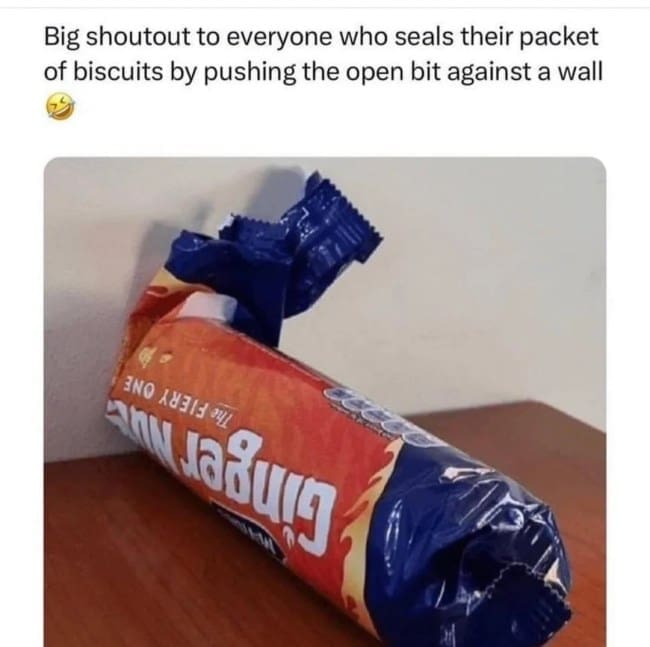 A photo of a crushed package of ginger nuts biscuits being used to seal the open end.